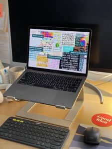 Laptop on desk with 2024 Intentions board as background