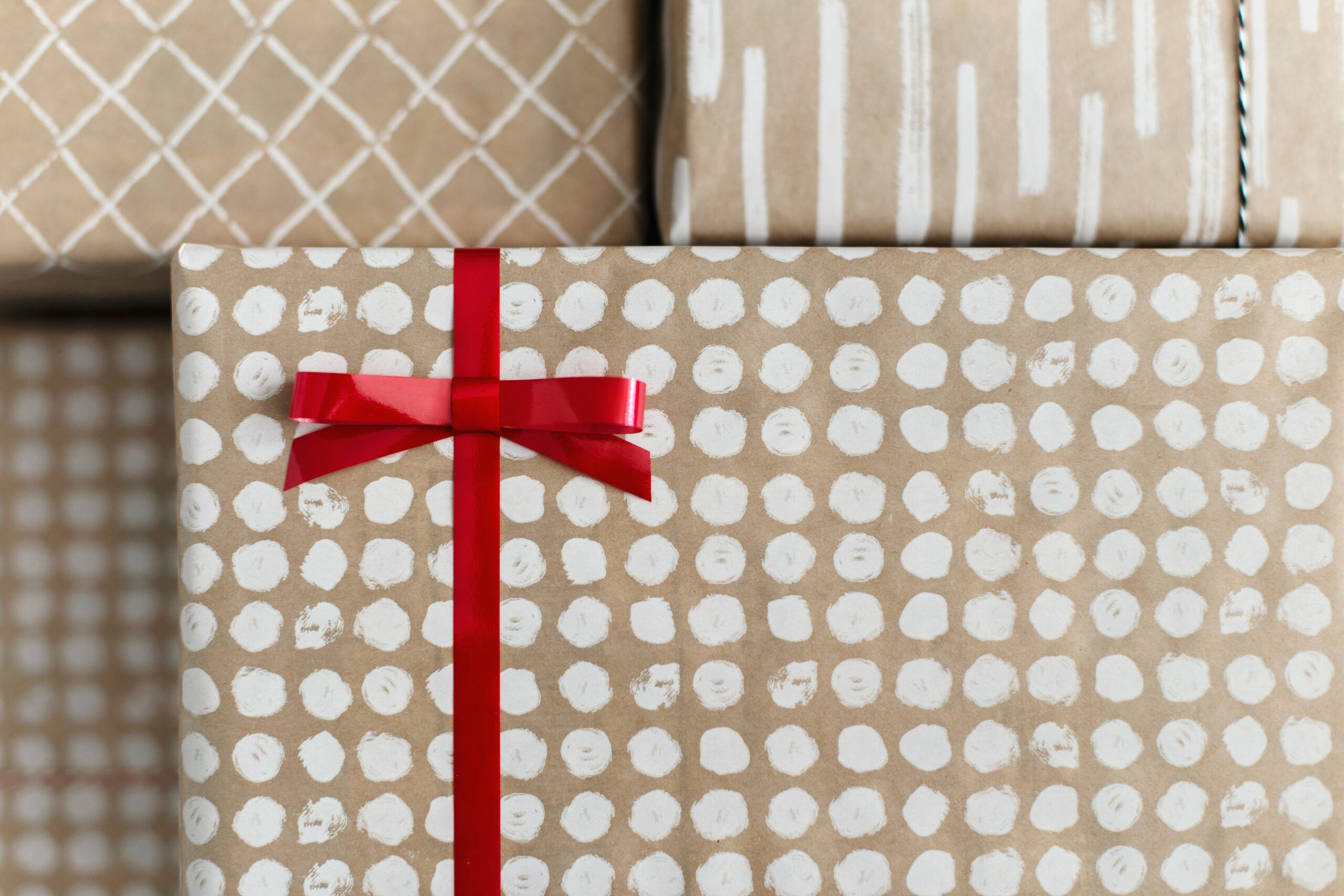 Several gifts in brown paper one with red bow